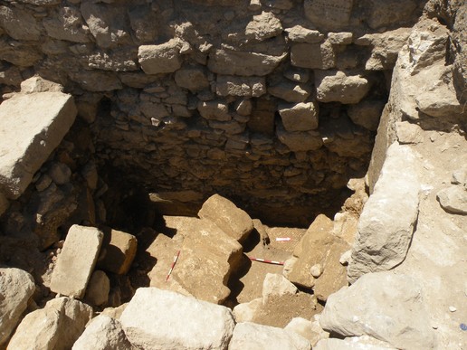 Fig. 24. Trench T5: a lower layer of the Umayyad-period debris with a fallen pillar and the monochrome mosaic floor below it; view from the East (image by Mariusz Burdajewicz).